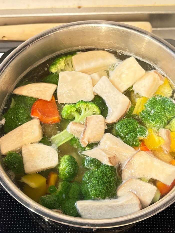 鶏肉を取り出した鍋で野菜をゆでている写真